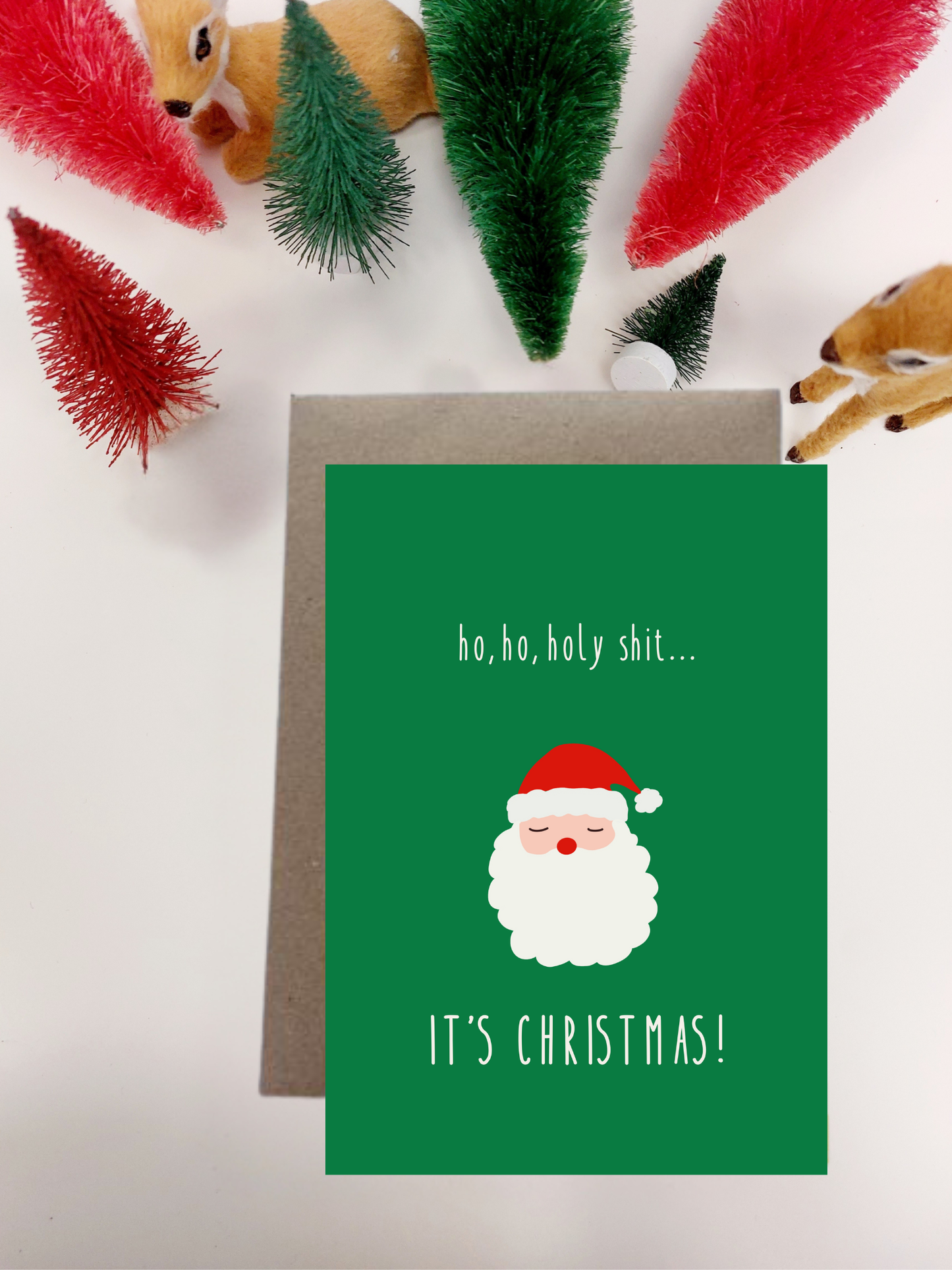Irish Made Christmas card with Santa Claus illustration and humorous text on a green background, surrounded by festive decorations.