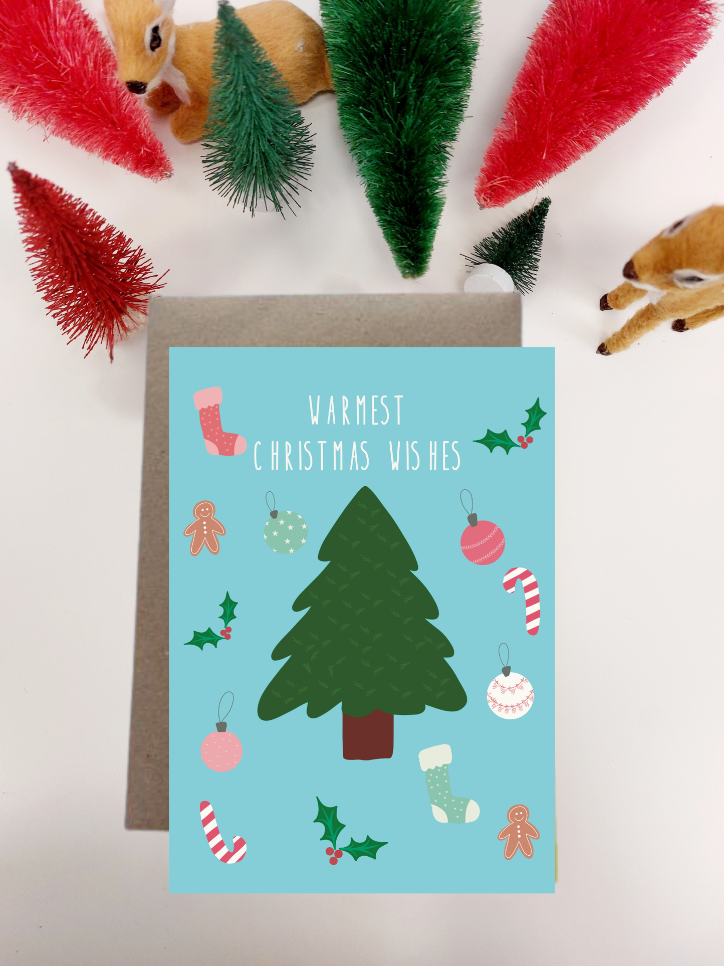Irish made Christmas card with festive illustrations on a light blue background, surrounded by decorative items.